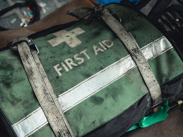 tas met wit kruis erop en tekst 'first aid'